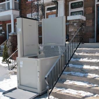 Savaria Multilift Vertical Platform Lift in front of a home next to snow-covered steps