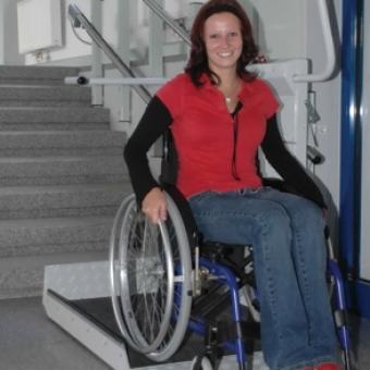 Smiling woman in a wheelchair using the Savaria Delta Inclined Platform Lift