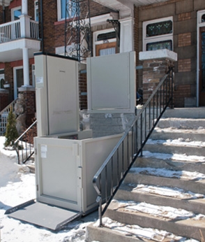 Savaria Multilift Vertical Platform Lift in front of a home next to snow-covered steps